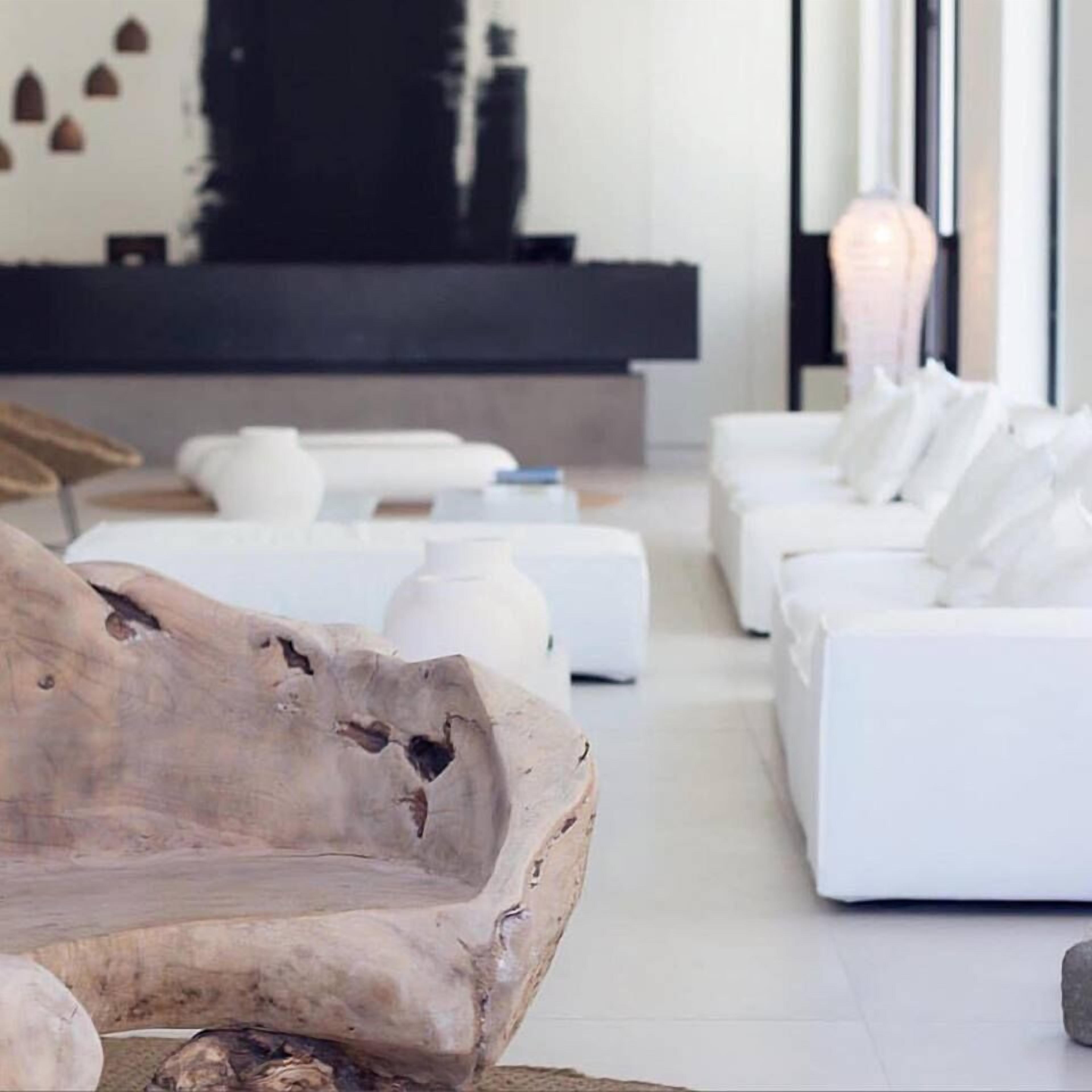 Ein modernes Wohnzimmer mit einem großen Holztisch, weißen Sofas und einem Kamin.