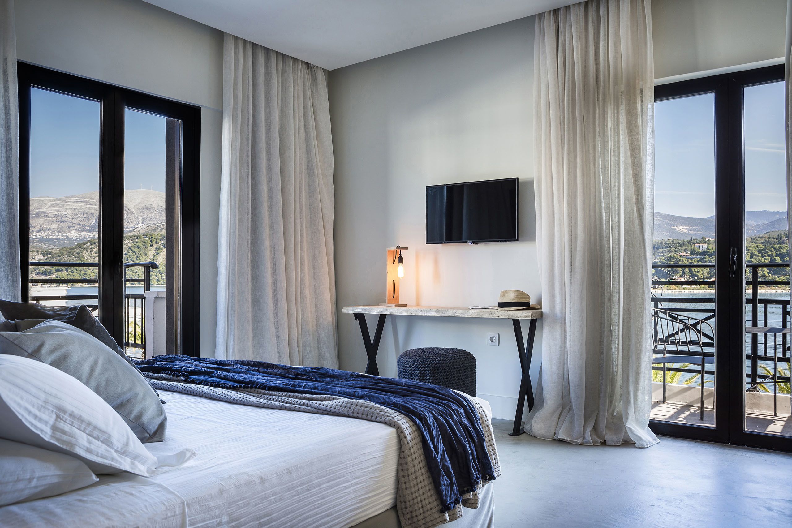 Une chambre d’hôtel avec un lit, un bureau avec une télévision et une vue sur l’extérieur.