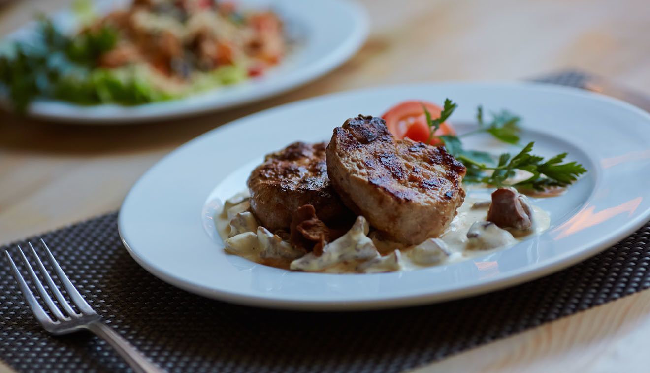 Un plato con carne a la parrilla y verduras sobre una mesa.