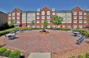 A hotel courtyard with a central fountain, surrounded by outdoor seating and greenery.