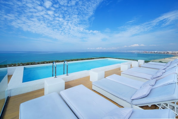 Piscine extérieure, parasols de plage, chaises longues