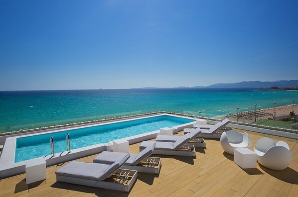 室外游泳池，提供泳池遮陽傘和日光浴躺椅