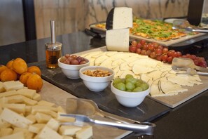 A cheese and fruit platter with various cheeses, grapes, and nuts on a table. - HM Tropical Hotel (Palma de Mallorca)