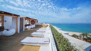 A rooftop terrace with lounge chairs and a view of the sea. - HM Tropical Hotel (Palma de Mallorca)