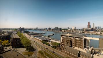 Een stadsgezicht met een rivier, gebouwen en een brug.