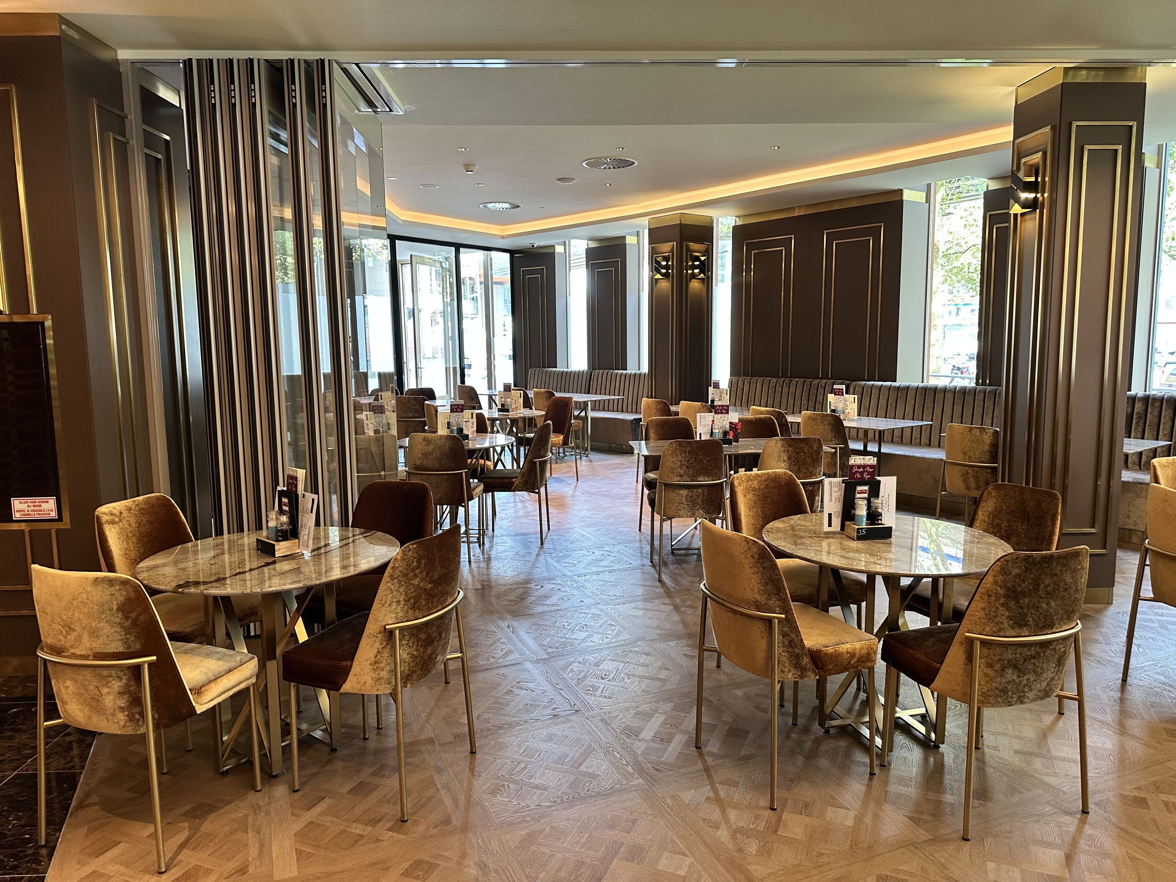 Ein geräumiges Restaurant mit hohen Decken, großen Fenstern und einem modernen Innenraum.