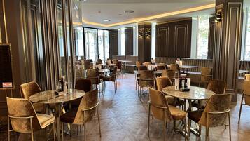 Ein geräumiges Restaurant mit hohen Decken, großen Fenstern und einem modernen Innenraum.