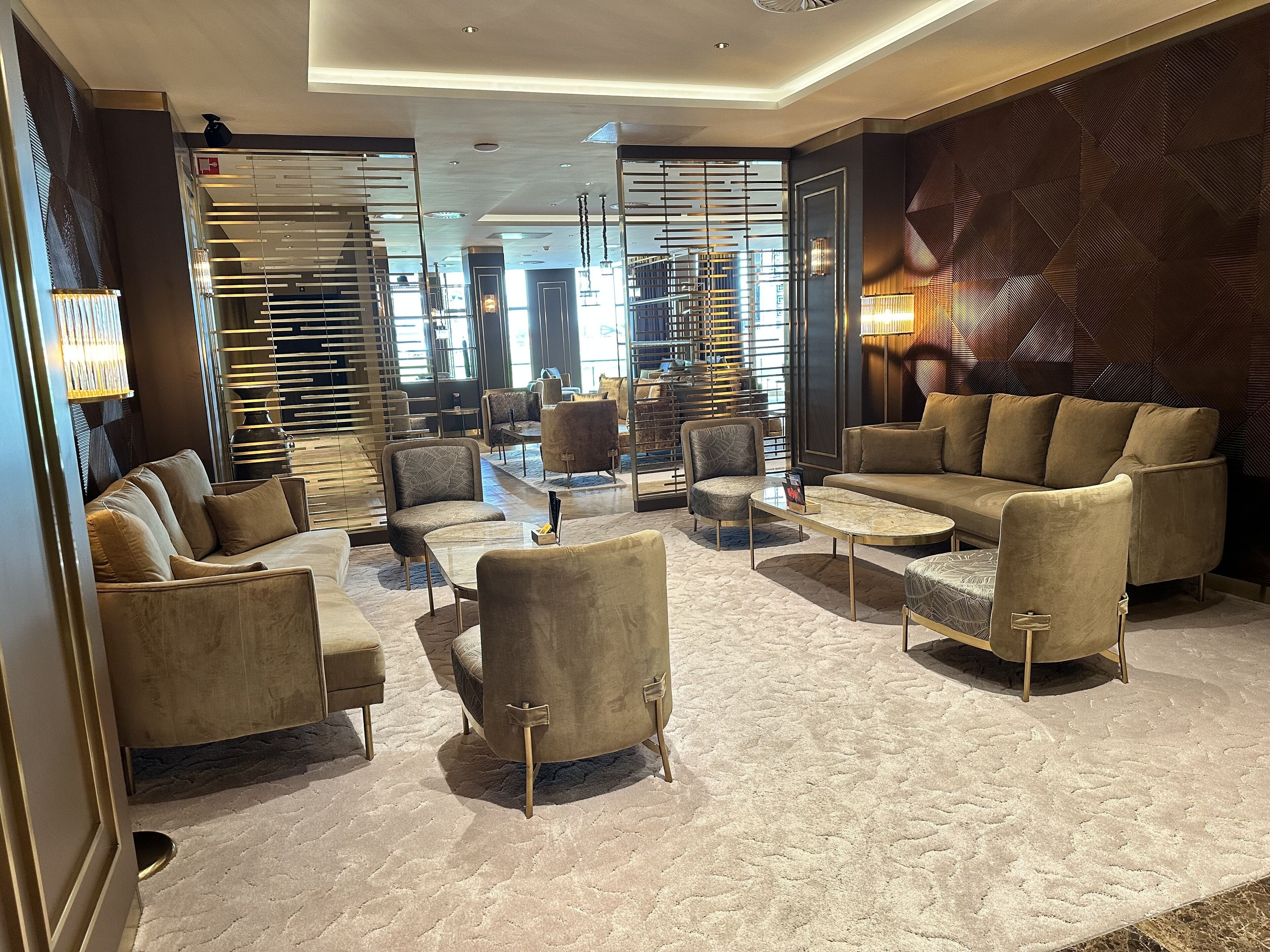 Eine moderne Lobby mit einer Couch, Sesseln und einem Couchtisch.