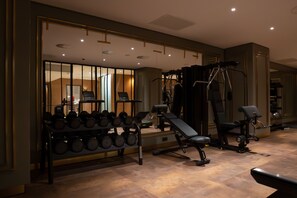A gym with exercise equipment, a bench, and a rack of dumbbells. - Art Hotel Rotterdam (Rotterdam)