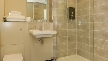 Un baño moderno con inodoro, lavamanos y ducha.