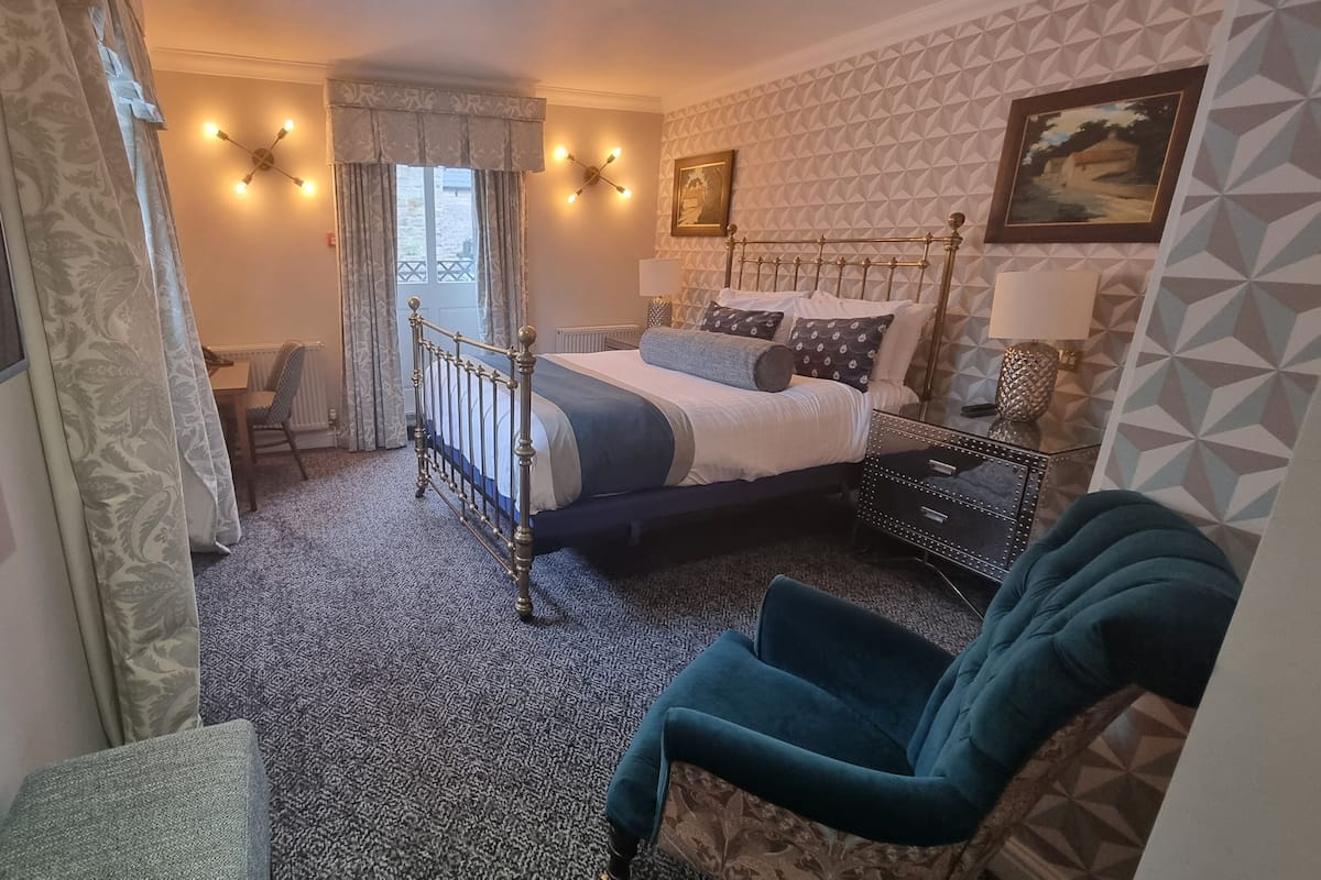Ein Schlafzimmer mit Bett, Stuhl, Schreibtisch und Fenster.