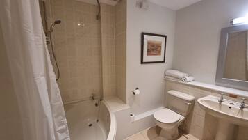 A bathroom with a bathtub, toilet, and sink.