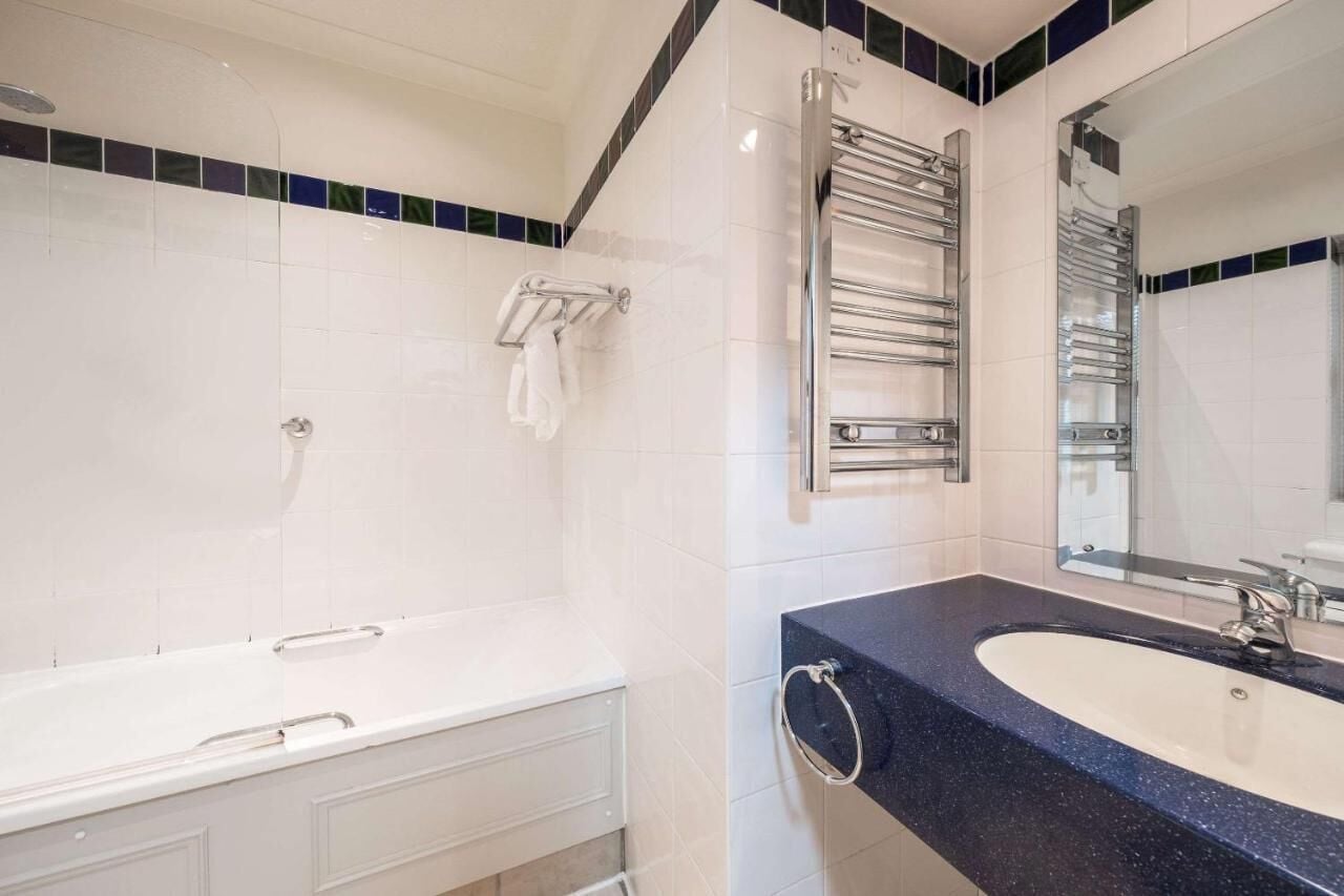 Ein modernes Badezimmer mit einer Badewanne, einem Waschbecken und einem großen Spiegel.