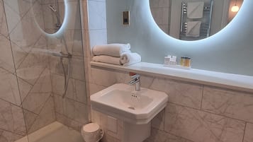 Une salle de bain moderne avec une douche à parois de verre, un lavabo et des toilettes.