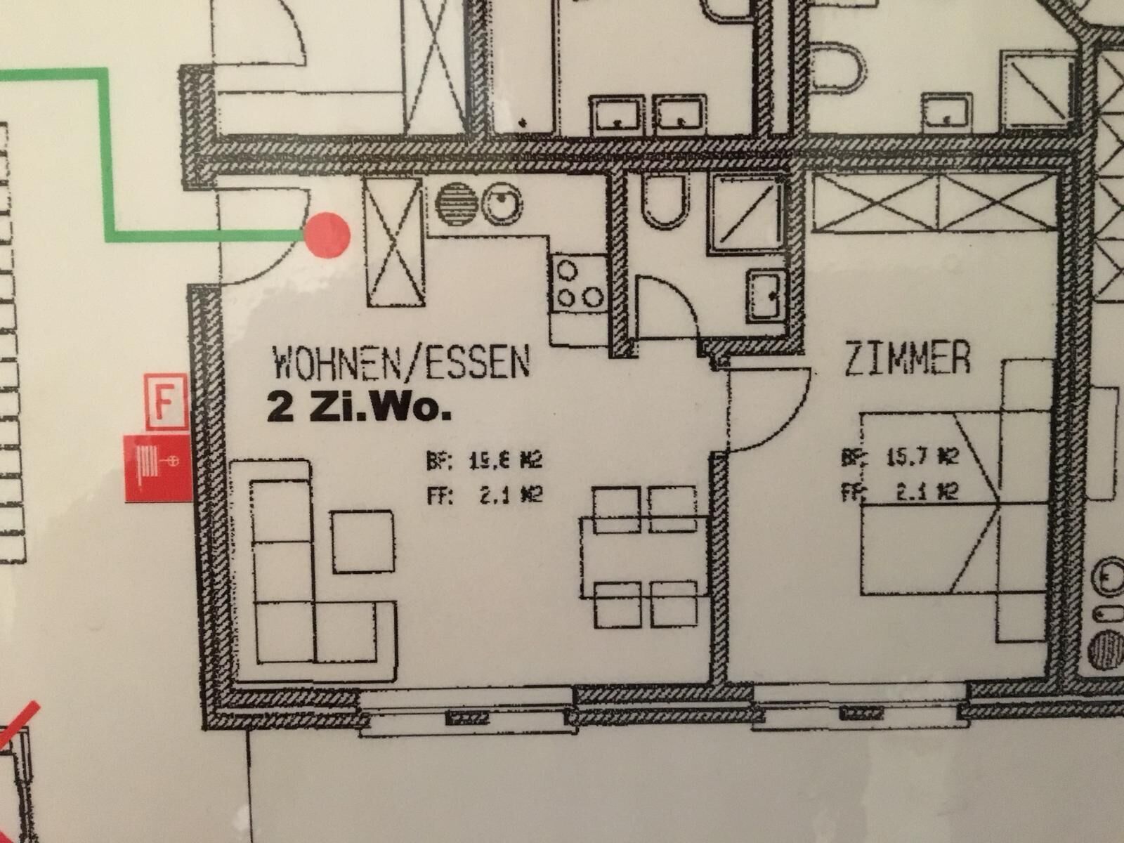 Een plattegrond van een hotelkamer met twee slaapkamers, een badkamer en een zithoek.