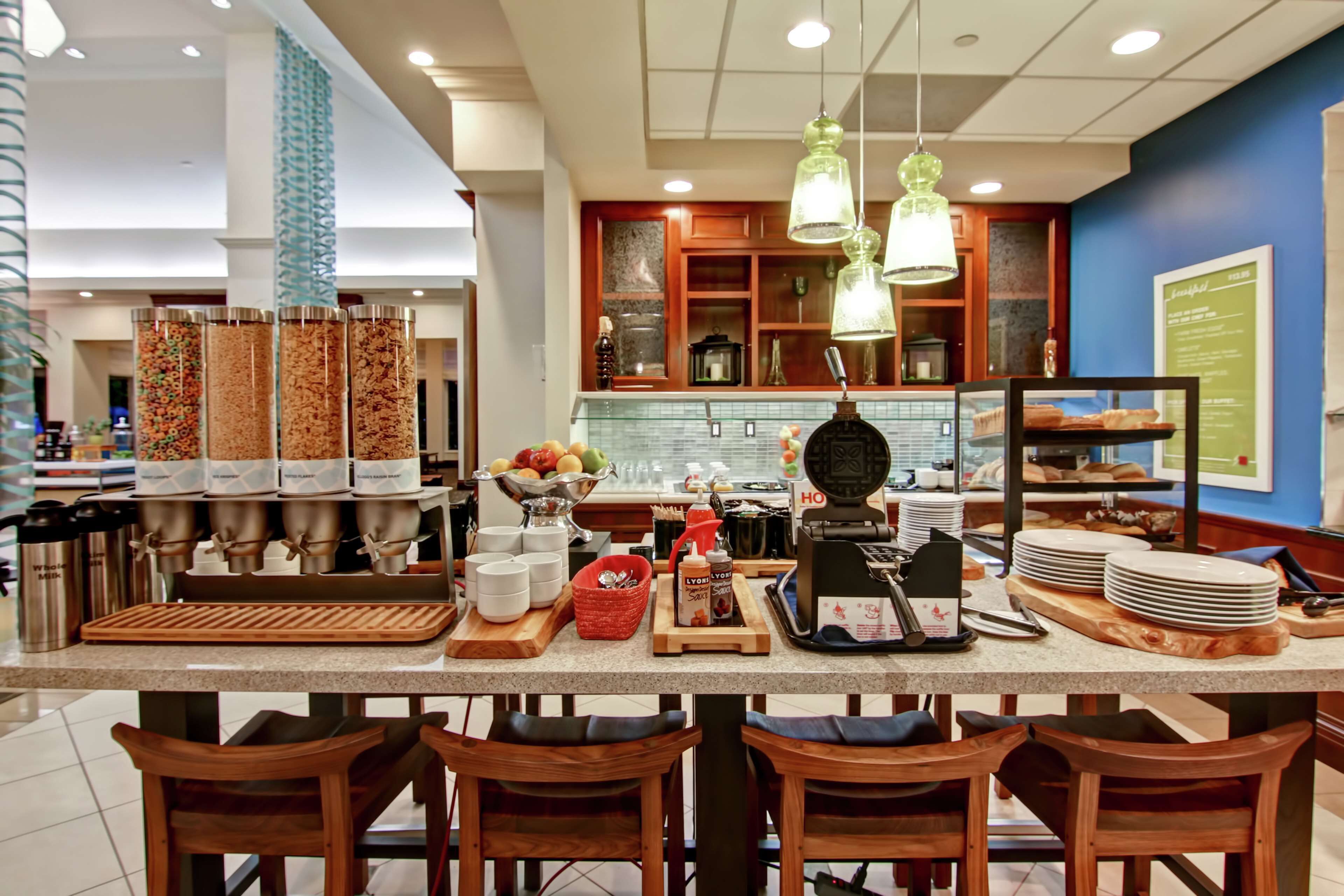 A breakfast bar with a coffee machine, a fruit bowl, and various condiments.