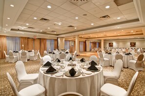 A banquet hall with round tables set for dining, white chairs, and a carpeted floor. - Hilton Garden Inn Toronto/Burlington (Burlington)