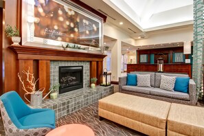 A spacious living area with a fireplace, seating, and a large window with a view.