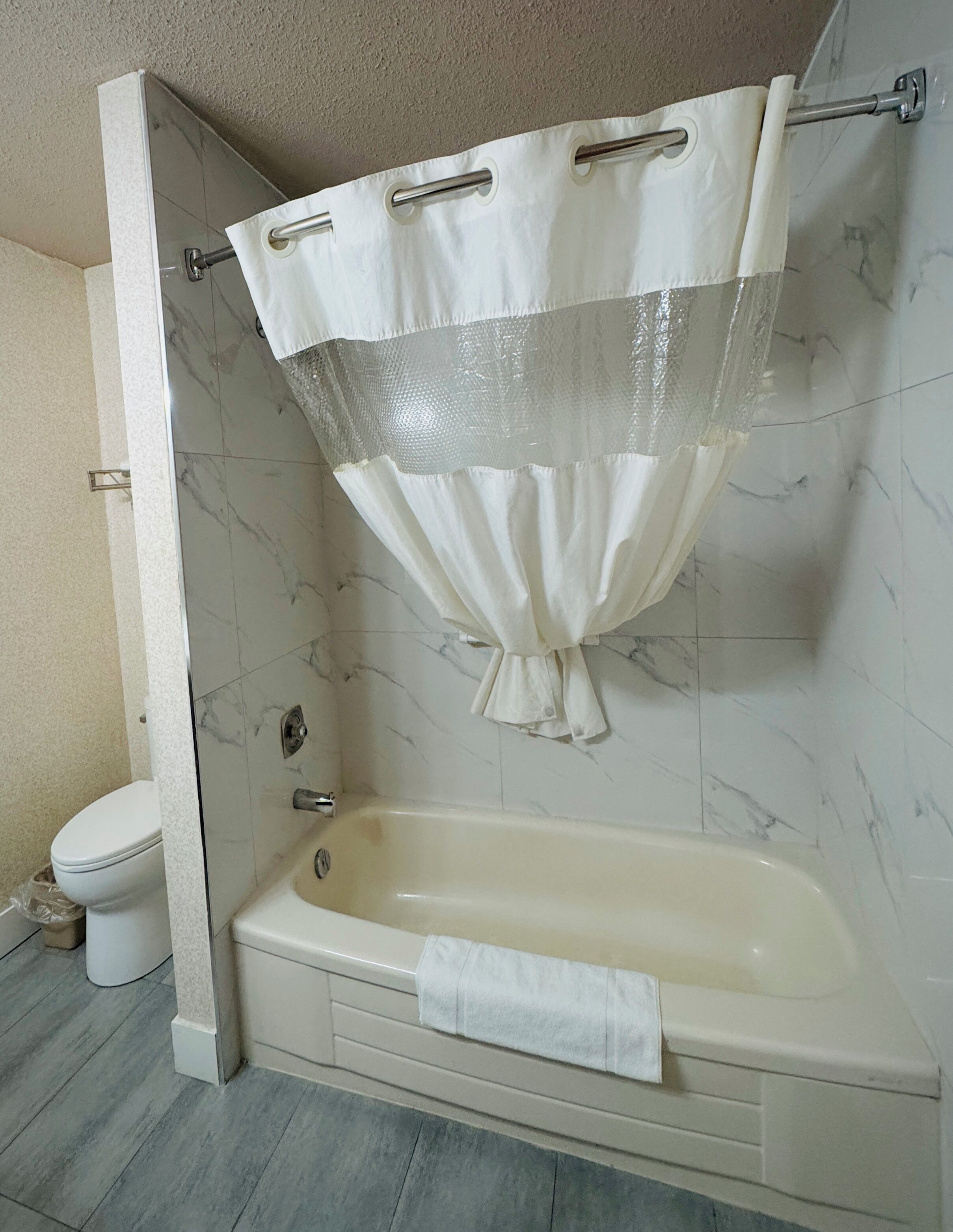 Un baño con bañera, inodoro y cortina de ducha.
