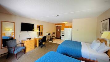 A hotel room with two beds, a desk, a chair, a television, a microwave, and a refrigerator.