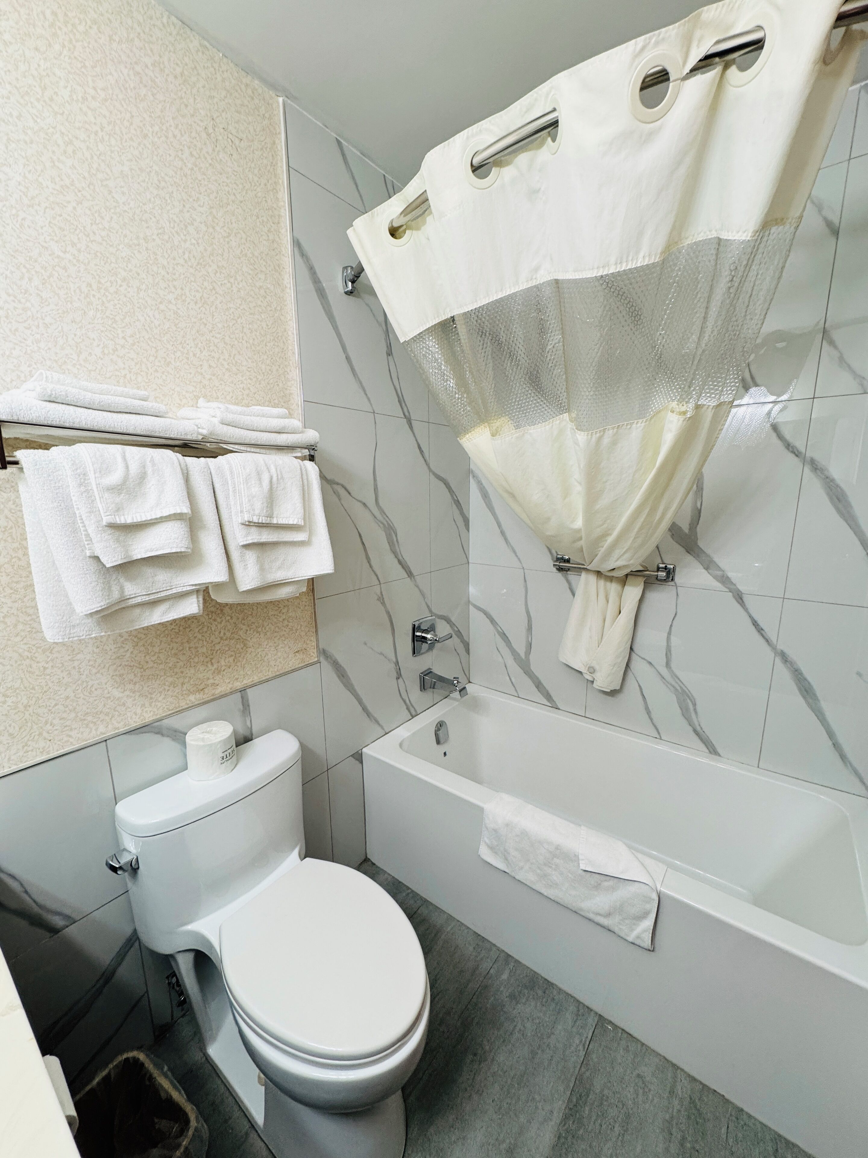 A bathroom with a toilet, a bathtub, and a shower curtain.