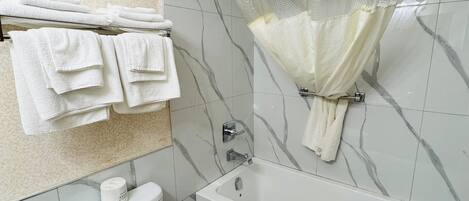A bathroom with a toilet, a bathtub, and a shower curtain.