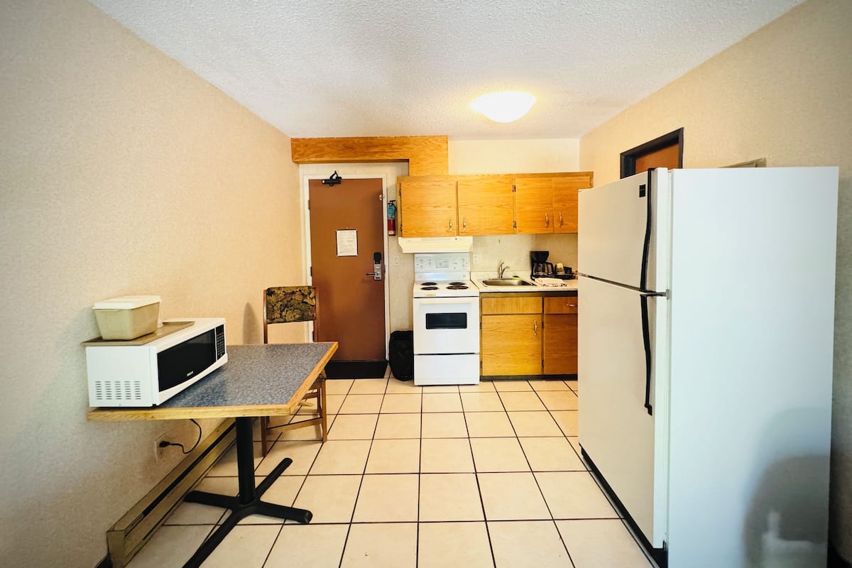 A compact kitchen with a microwave, stove, and refrigerator.