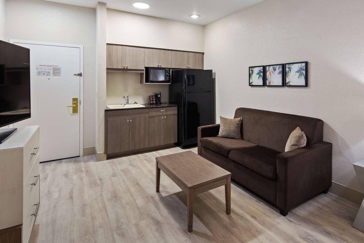 A compact living space with a kitchenette, a sofa, a coffee table, and a TV.