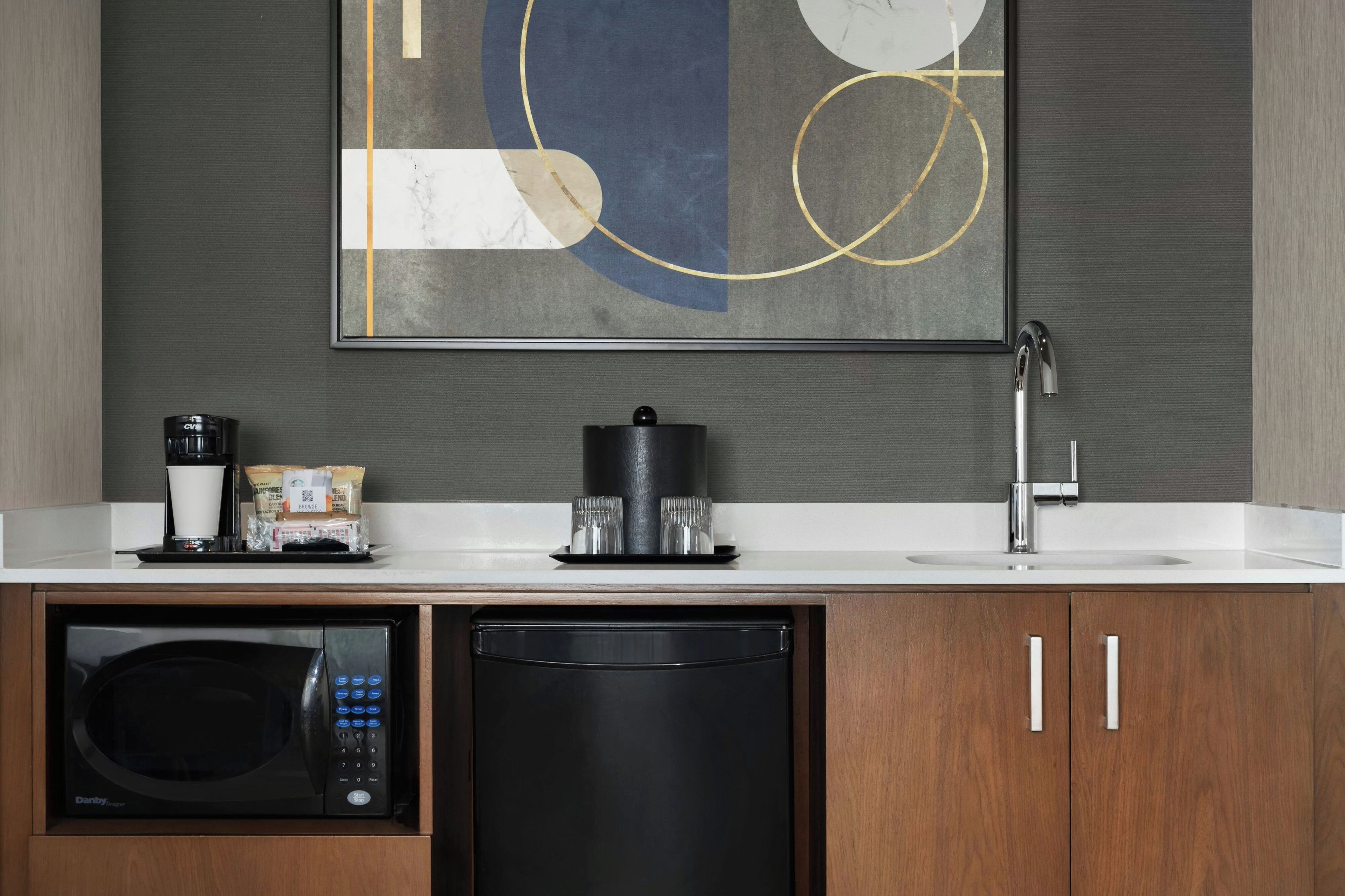 A modern kitchen with a microwave, coffee maker, and a coffee bag on the counter.