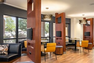 Un interior moderno con una zona de estar, divisiones de madera y grandes ventanales.