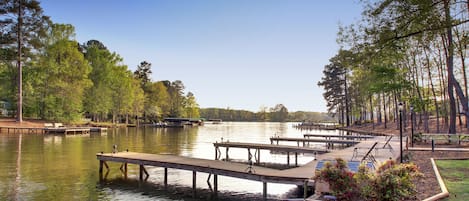 Un parque junto al lago con muelles de madera, mesas de picnic y bancos.