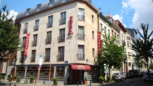 A multi-story hotel with a classic architectural style, featuring balconies and large windows. - Beverly Hills Hotel (Brussels)