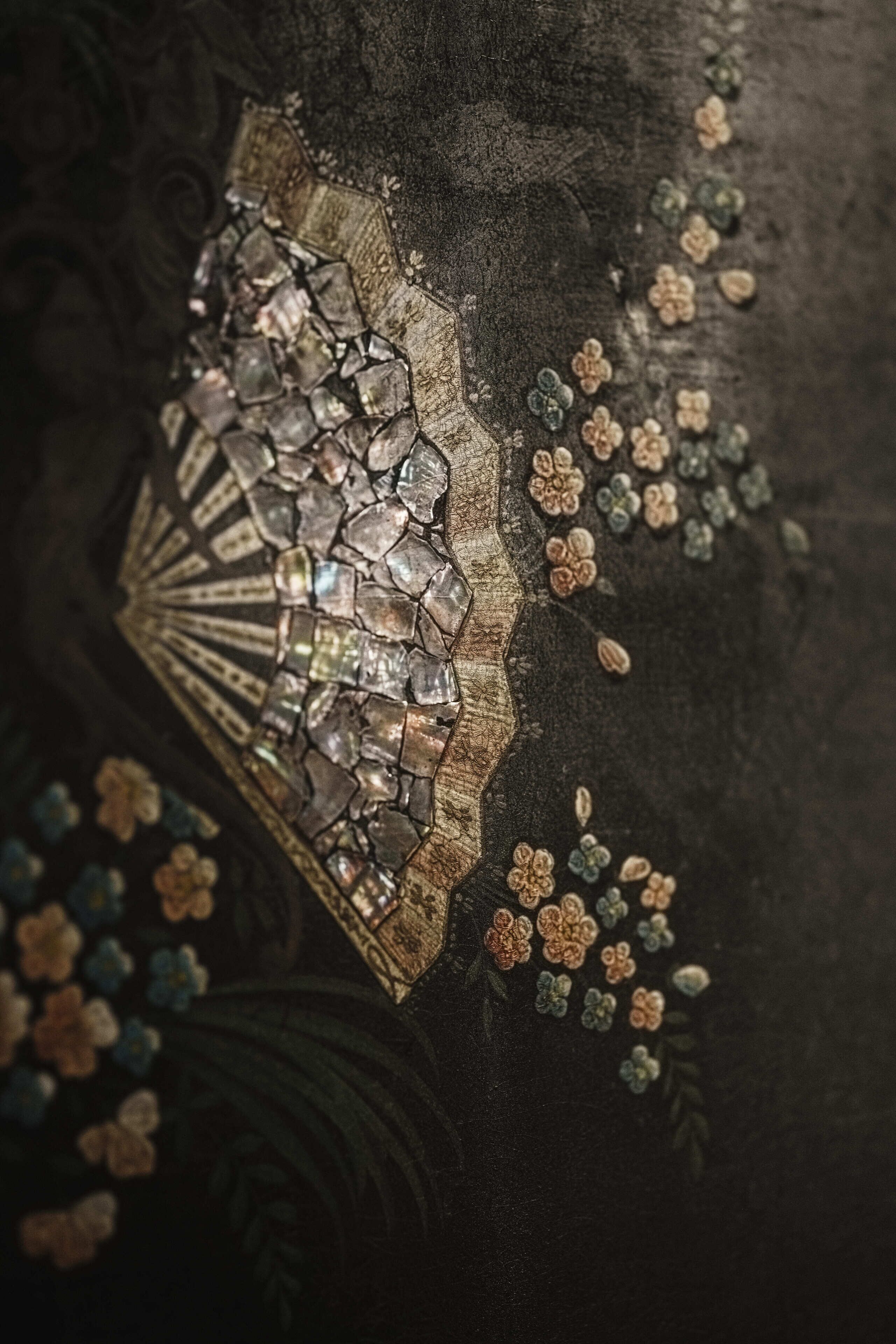 A close-up of a decorative mosaic with floral patterns and a fan-like structure.