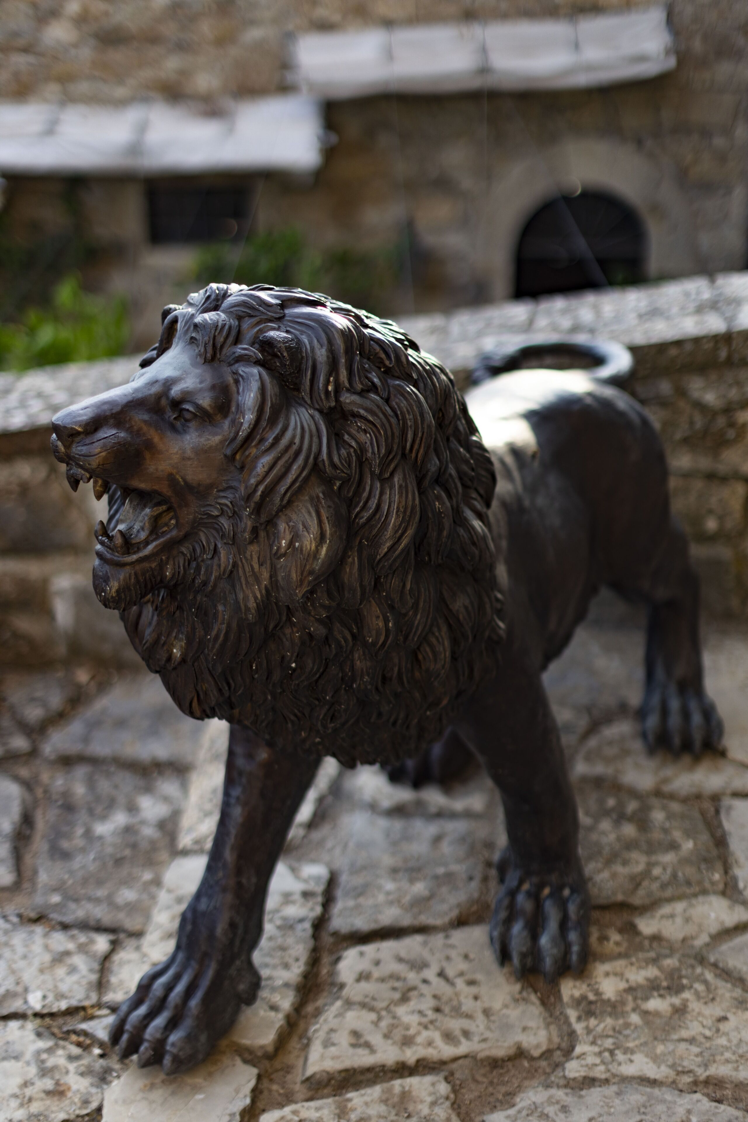 A stone lion statue on a stone platform.