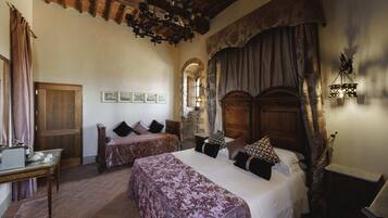 Una habitación tradicional con una cama, un escritorio de madera y una pared de piedra.