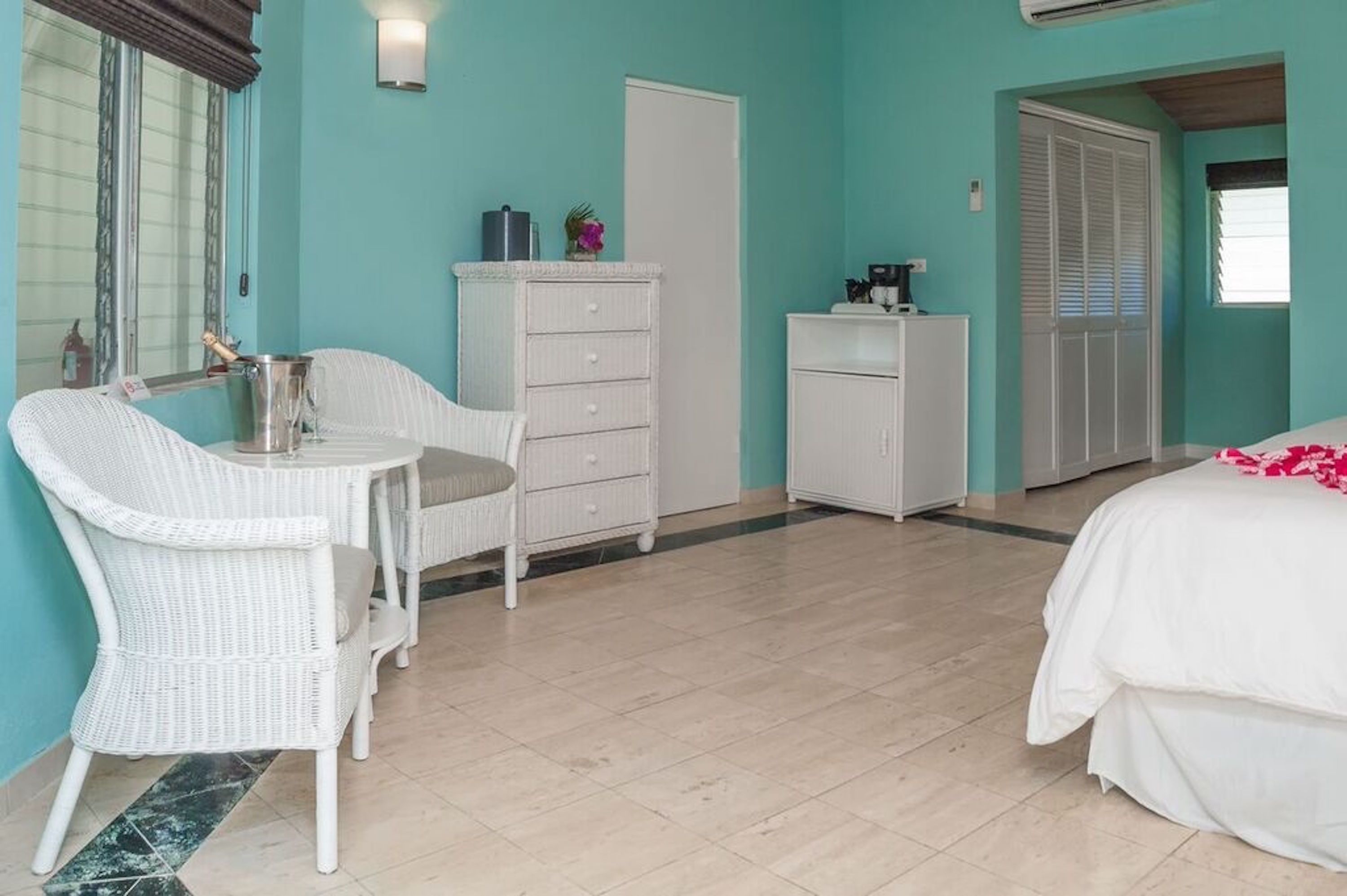 Un dormitorio con una cama, un aparador, una silla y una mesita.