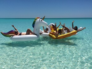 A group of people floating on a beach with clear turquoise water and a clear sky. - Cape Santa Maria Beach Resort (Galliot Cay)