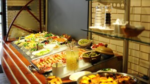 A buffet with various food items and a glass display case.