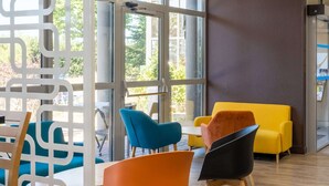 A modern interior with a glass partition, wooden furniture, and a yellow sofa.