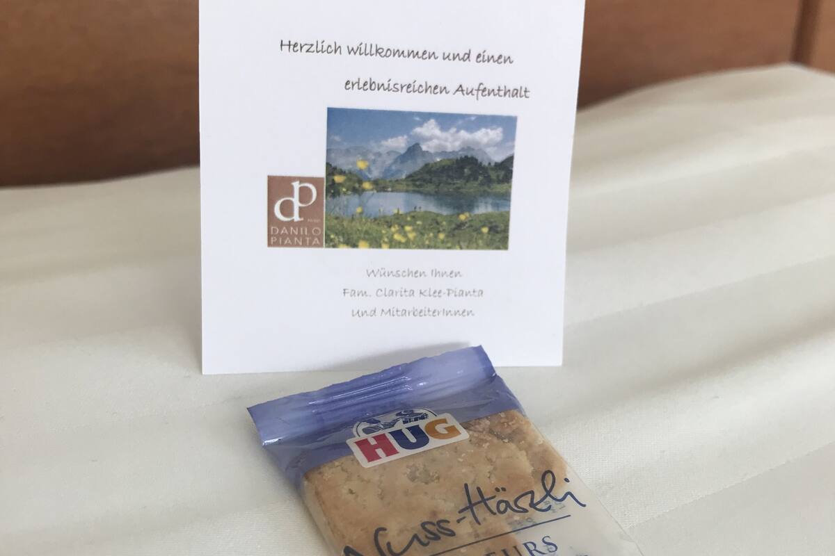 A welcome card with a scenic mountain view, a packet of cookies, and a small blue and white package.