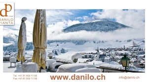 A snowy landscape with a mountain and a town.