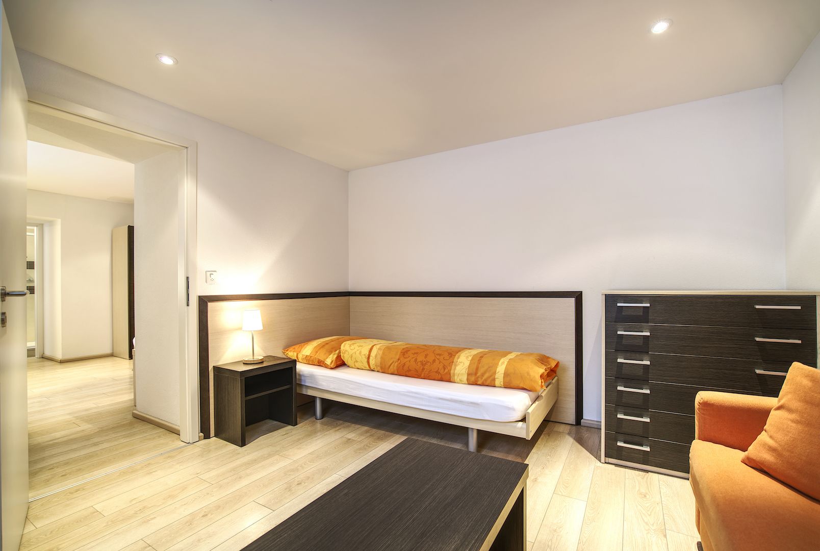 Un dormitorio moderno con cama, mesita de noche y armario.