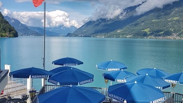 Une terrasse au bord du lac, dotée de sièges extérieurs et ornée d’un drapeau.