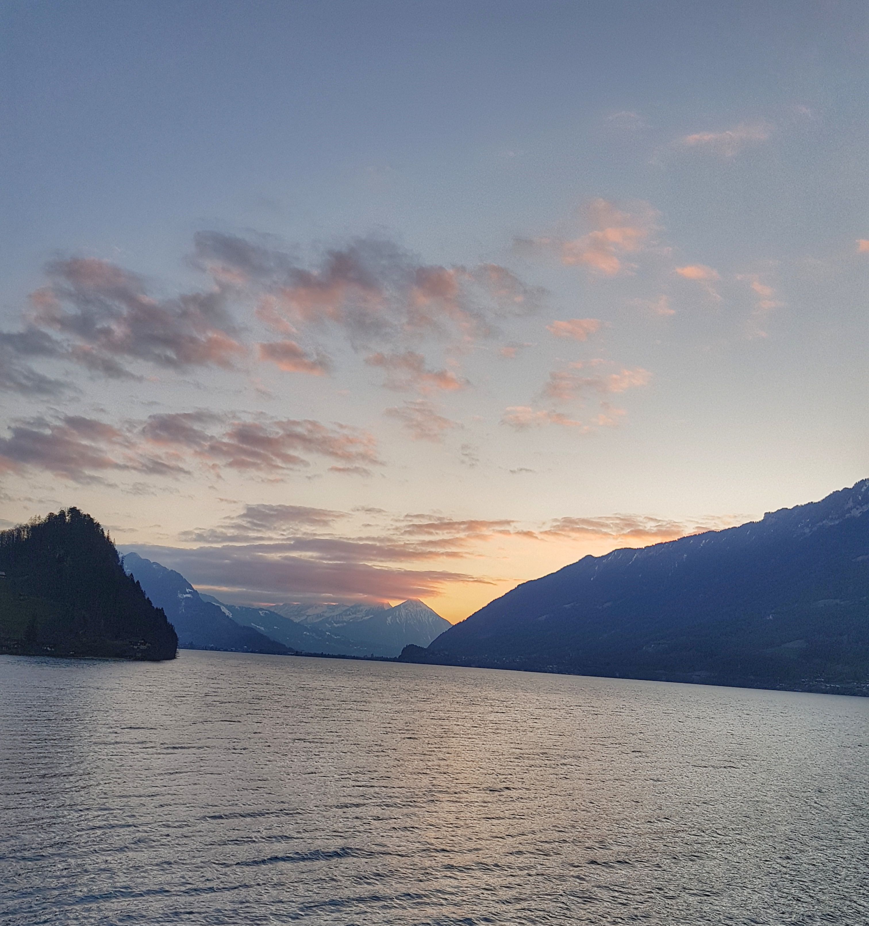 Un lac paisible, avec des montagnes en arrière-plan.
