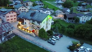 Un hôtel avec une enseigne bien visible indiquant « HÔTEL », un parking et des immeubles résidentiels à proximité.