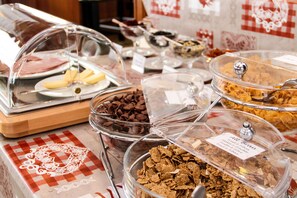 A buffet with various food items including cereal, chocolate, and cheese. - Pointe de Zinal (Anniviers)