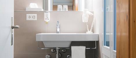A bathroom with a sink, mirror, towel rack, and a hairdryer.