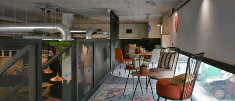 A modern interior with a dining area, a sofa, and a view of the street.
