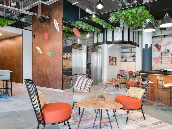 Un interior moderno con una zona de bar, asientos y una cocina visible a través de un mamparo de vidrio.