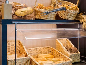 A bakery display with various breads and pastries in wicker baskets. - Hotel ibis Madrid Getafe (Getafe)